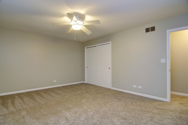 467 Sheffield Road Naperville, IL 60565 - Photo 10 of 19 an empty room with a chandelier fan and windows