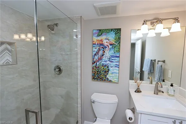a bathroom with a sink vanity mirror and toilet