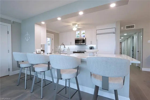 a kitchen with kitchen island a dining table and chairs