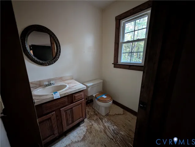a bathroom with a granite countertop toilet sink and mirror