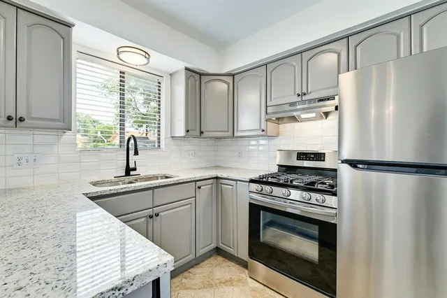 a kitchen with a stove a refrigerator and a sink