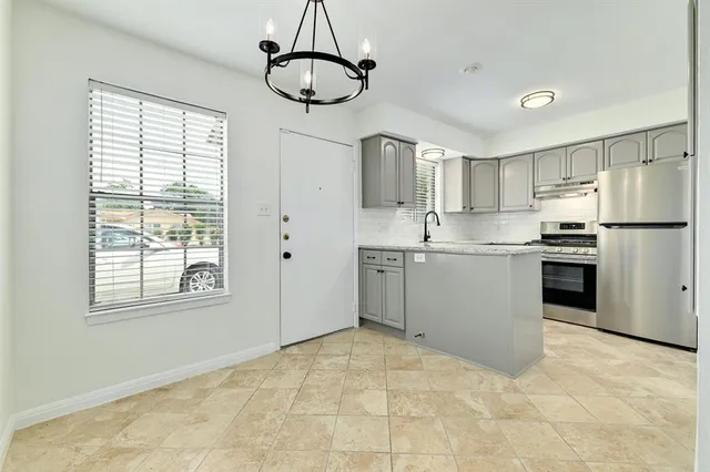 a kitchen with stainless steel appliances granite countertop a stove a sink dishwasher a refrigerator and a counter space