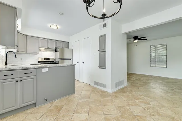 a kitchen with kitchen island a counter top space appliances and cabinets