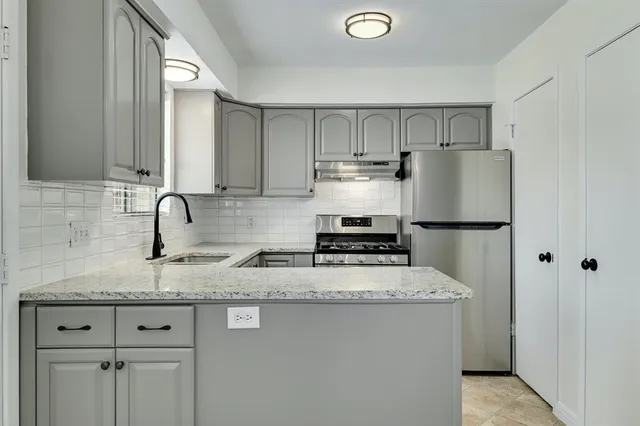 a kitchen with stainless steel appliances granite countertop a sink stove and refrigerator