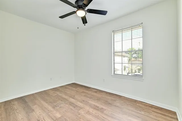 an empty room with a window and a fan