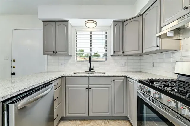 a kitchen with cabinets appliances a sink and a window