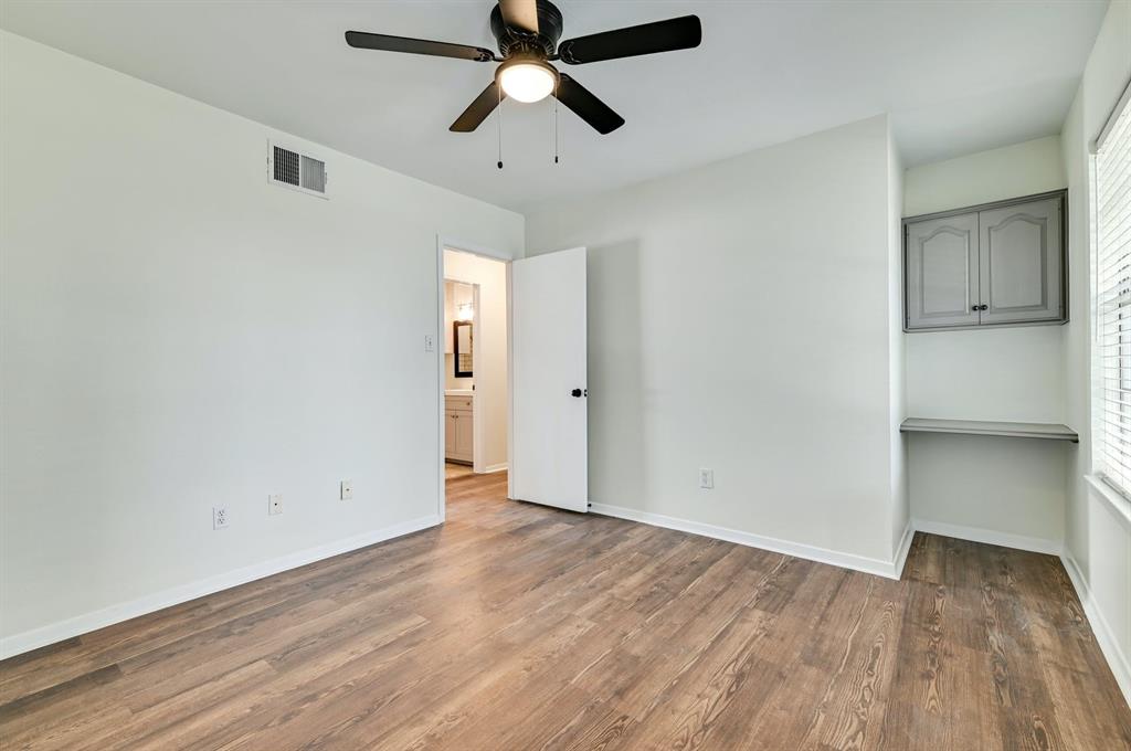 204 Northwest Drive, Unit B Round Rock, TX 78664 - Photo 23 of 25 an empty room with wooden floor ceiling fan and windows