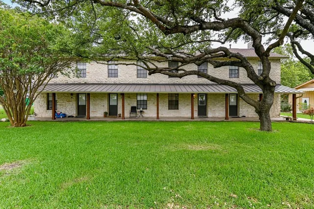 a view of a brick house with a large windows and a large tree