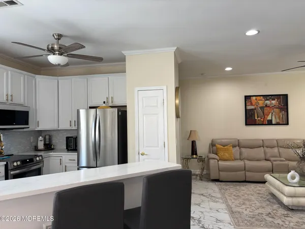 a kitchen with granite countertop white cabinets and stainless steel appliances
