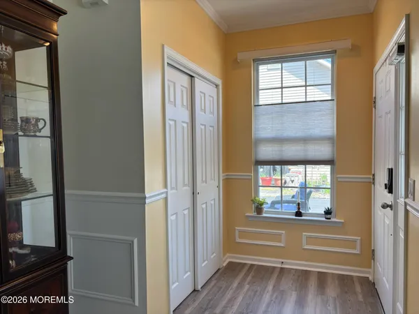 a view of a hallway with wooden floor and closet