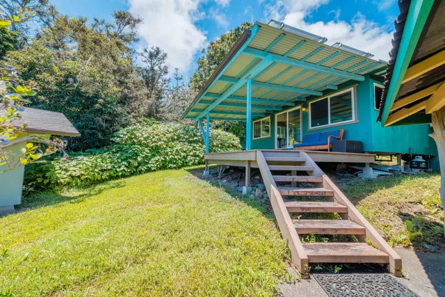 a backyard of a house with plants and tree