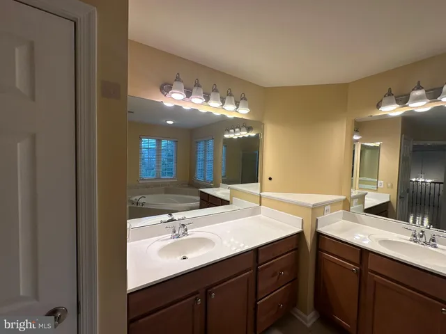 an empty room with wooden floor ceiling fan and windows