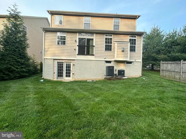 a view of a house with a big yard and large trees