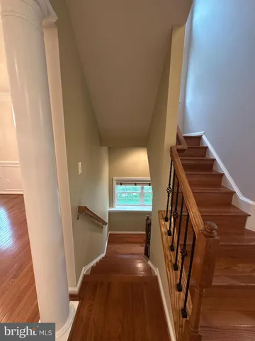 an empty room with wooden floor chandelier and windows