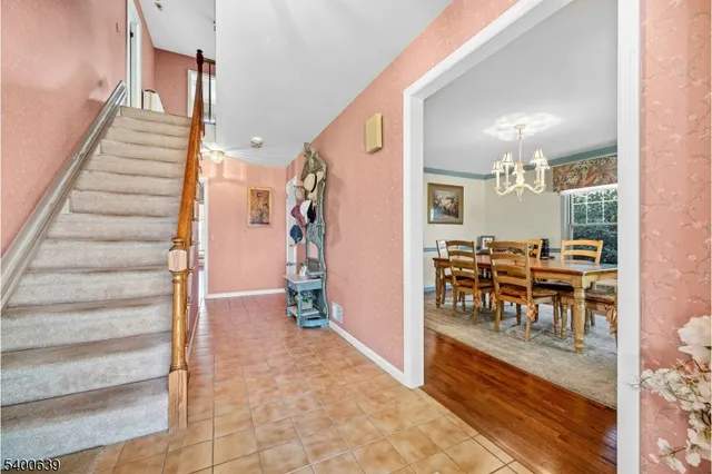 a view of a hallway with dining area and chandelier