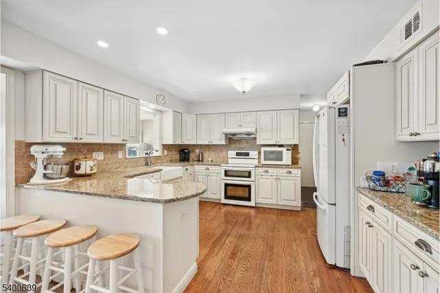 a kitchen with white cabinets and white appliances