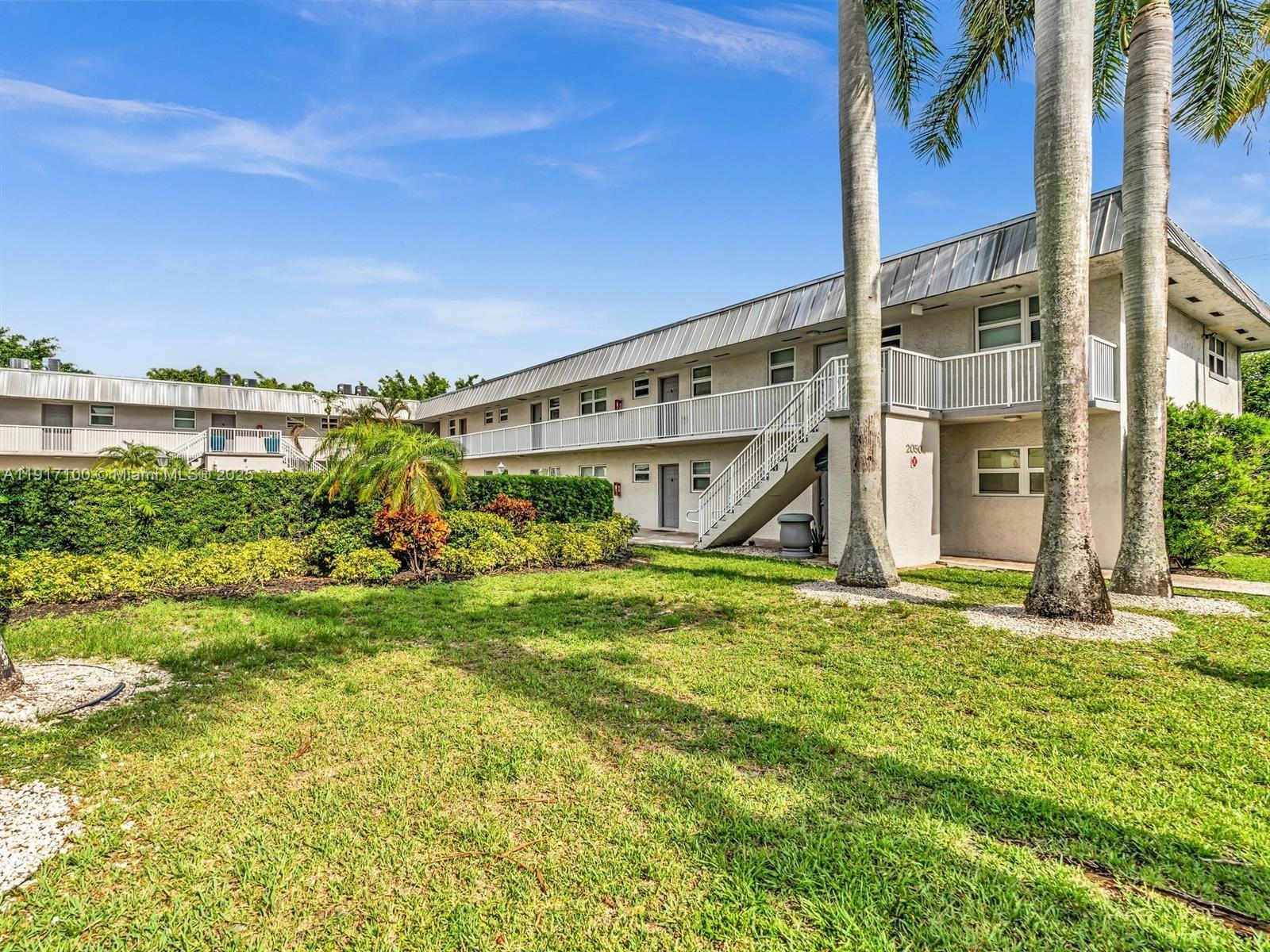 2050 Northwest 89th Avenue, Unit 211 Pembroke Pines, FL 33024 - Photo 4 of 14 a view of a house with a big yard and large tree