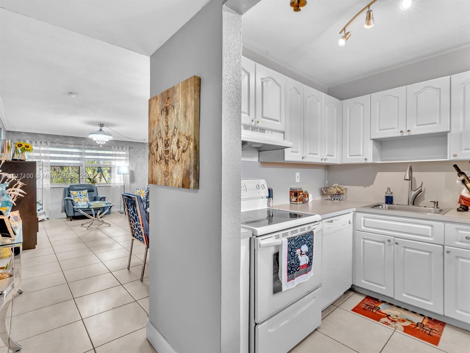 2050 Northwest 89th Avenue, Unit 211 Pembroke Pines, FL 33024 - Photo 5 of 14 a kitchen with a sink cabinets and window