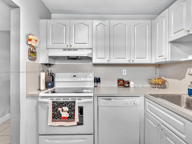 a kitchen with stainless steel appliances white cabinets and a refrigerator