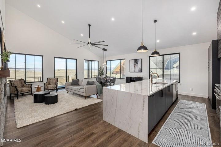 a large white kitchen with a large window a sink a counter space and stainless steel appliances