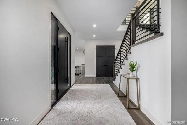 a view of a room with wooden floor and paintings on the wall