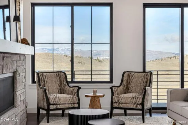 a living room with furniture fireplace and a large window