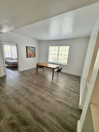 a bed sitting in a spacious bedroom next to a window