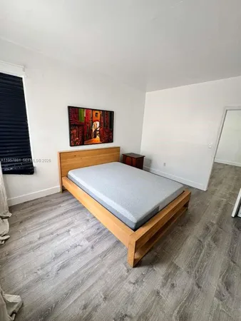a kitchen with stainless steel appliances a stove a sink dishwasher a refrigerator white cabinets and wooden floor