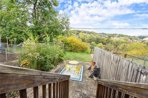 a view of a balcony with wooden floor and fence