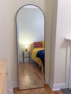a bedroom with a bed and a mirror