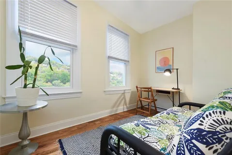 a bedroom with a bed table and a window