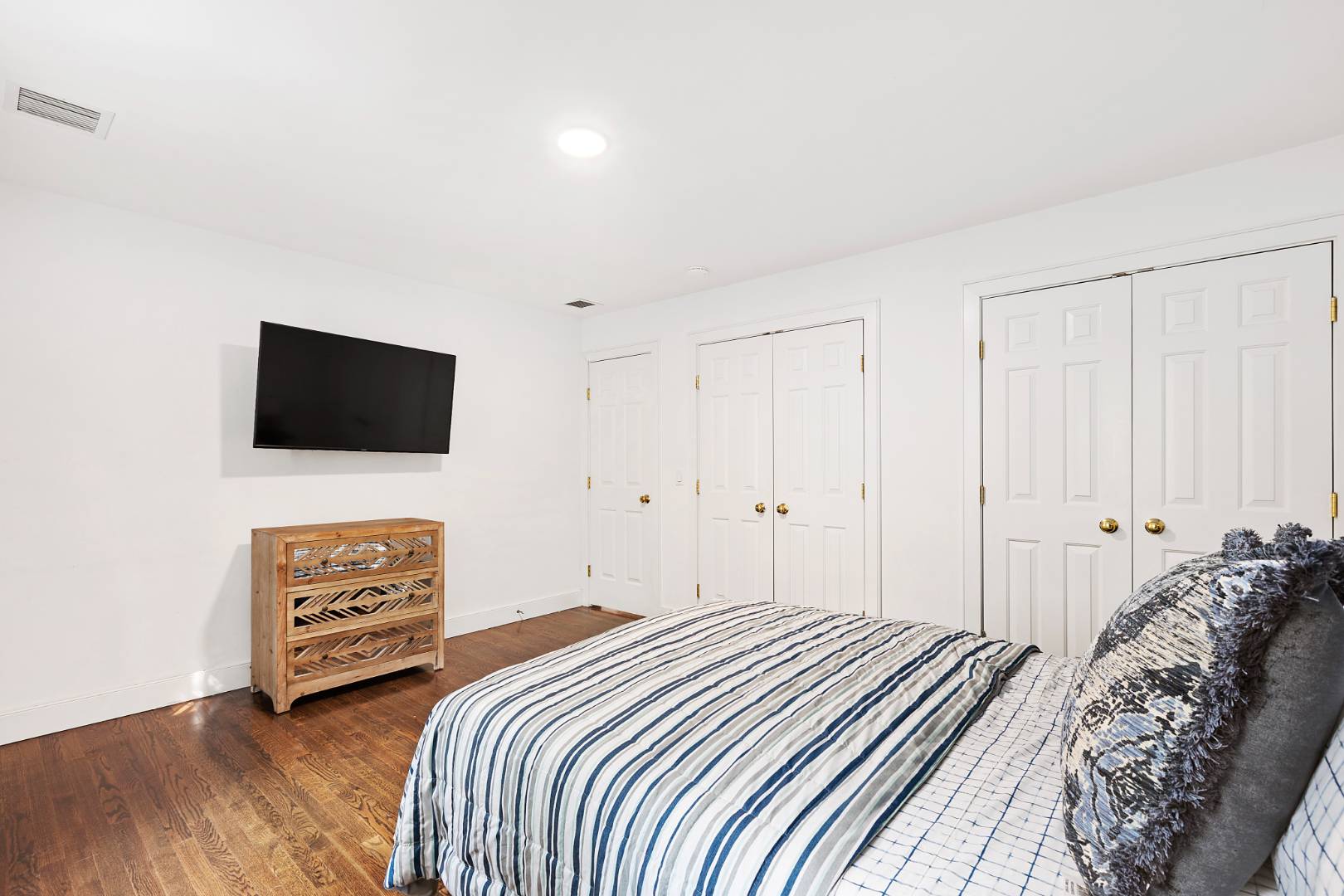 25 Old Sag Harbor Road Bridgehampton, NY 11963 - Photo 17 of 19 a bedroom with a bed and a flat screen tv