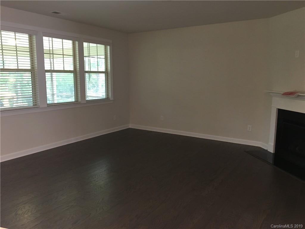 17535 Shearer Road Davidson, NC 28036 - Photo 9 of 22 an empty room with wooden floor and windows with curtains