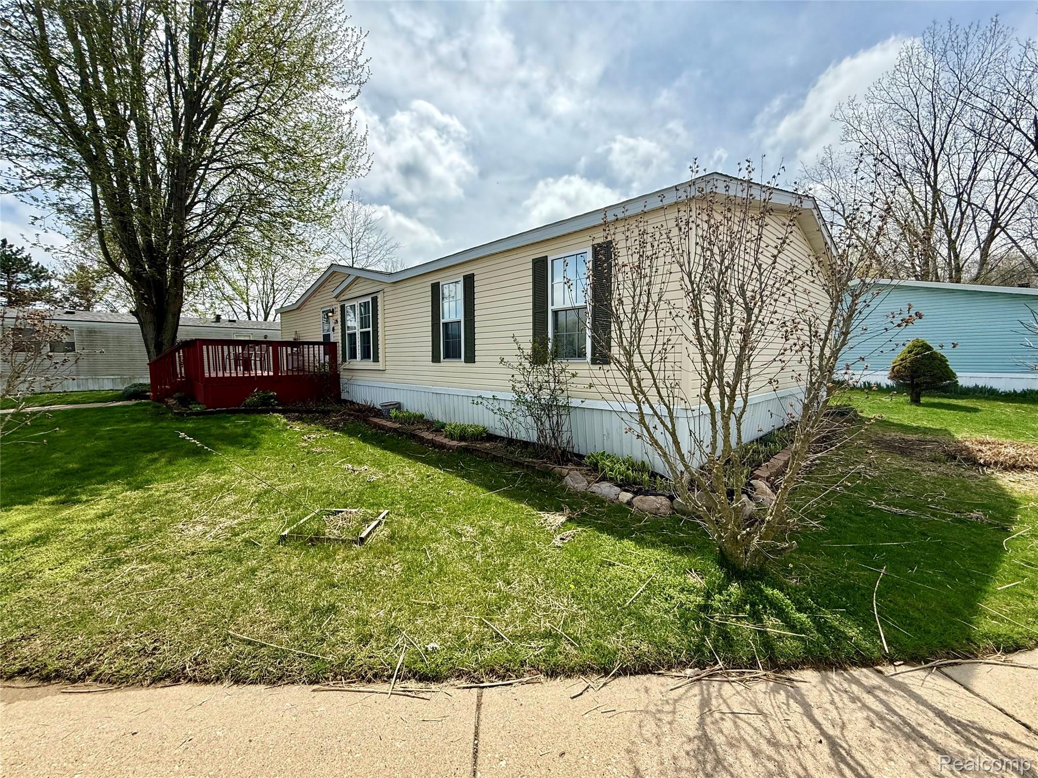 6988 McKean Road Ypsilanti, MI 48197 - Photo 15 of 21 View of side of property featuring a lawn and a wooden deck