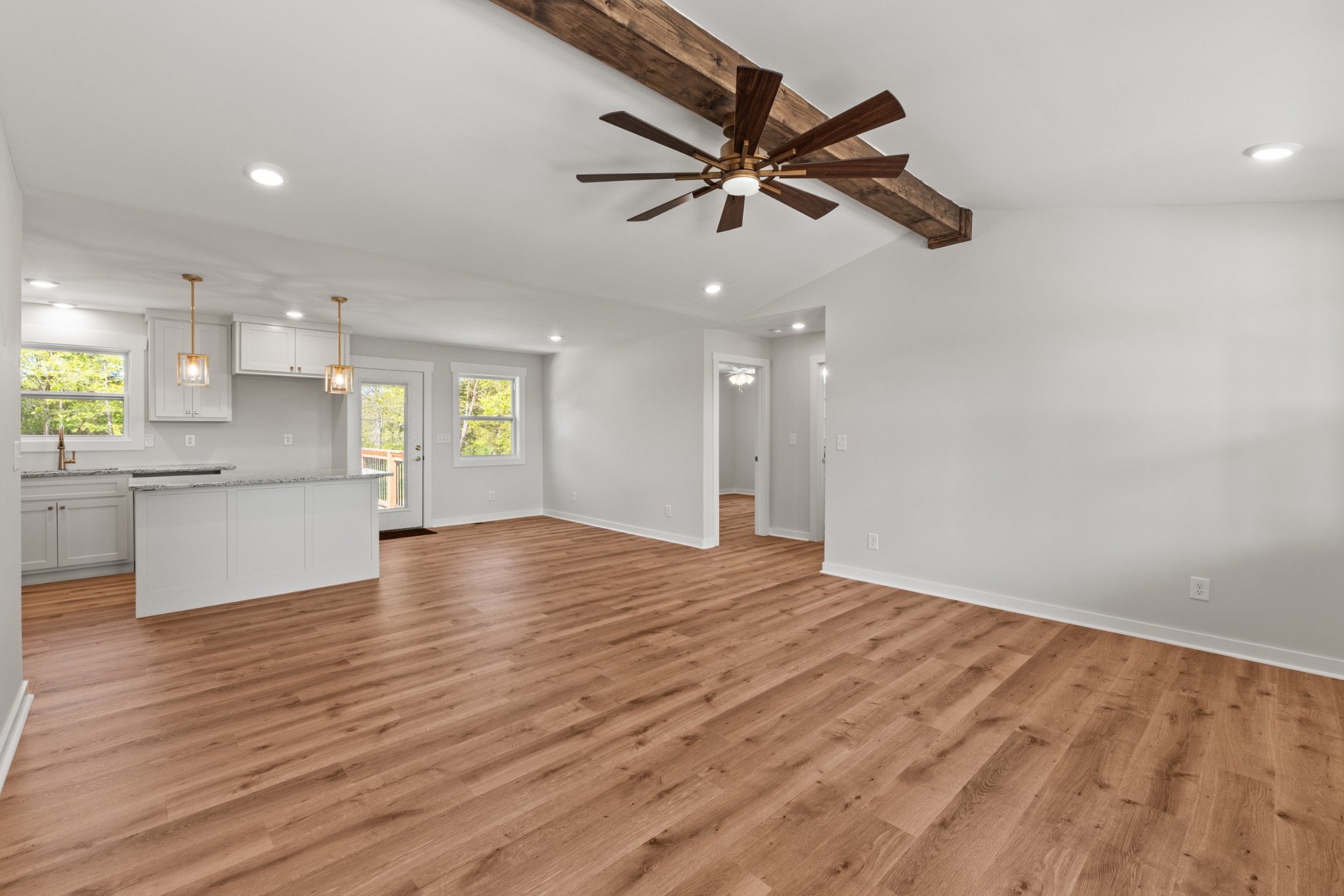 259 Patrick Road Fayetteville, TN 37334 - Photo 5 of 34 a view of an empty room and kitchen with wooden floor and a ceiling fan