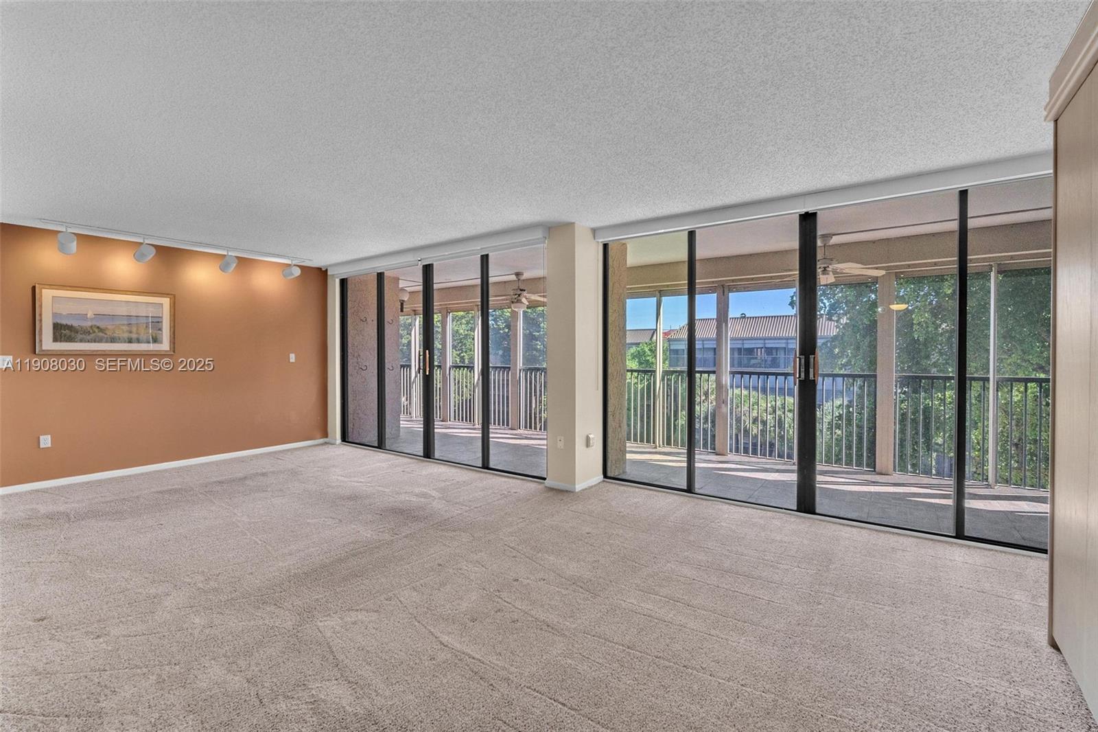 2810 North 46th Avenue, Unit F655 Hollywood, FL 33021 - Photo 16 of 52 a view of an empty room with windows and a balcony