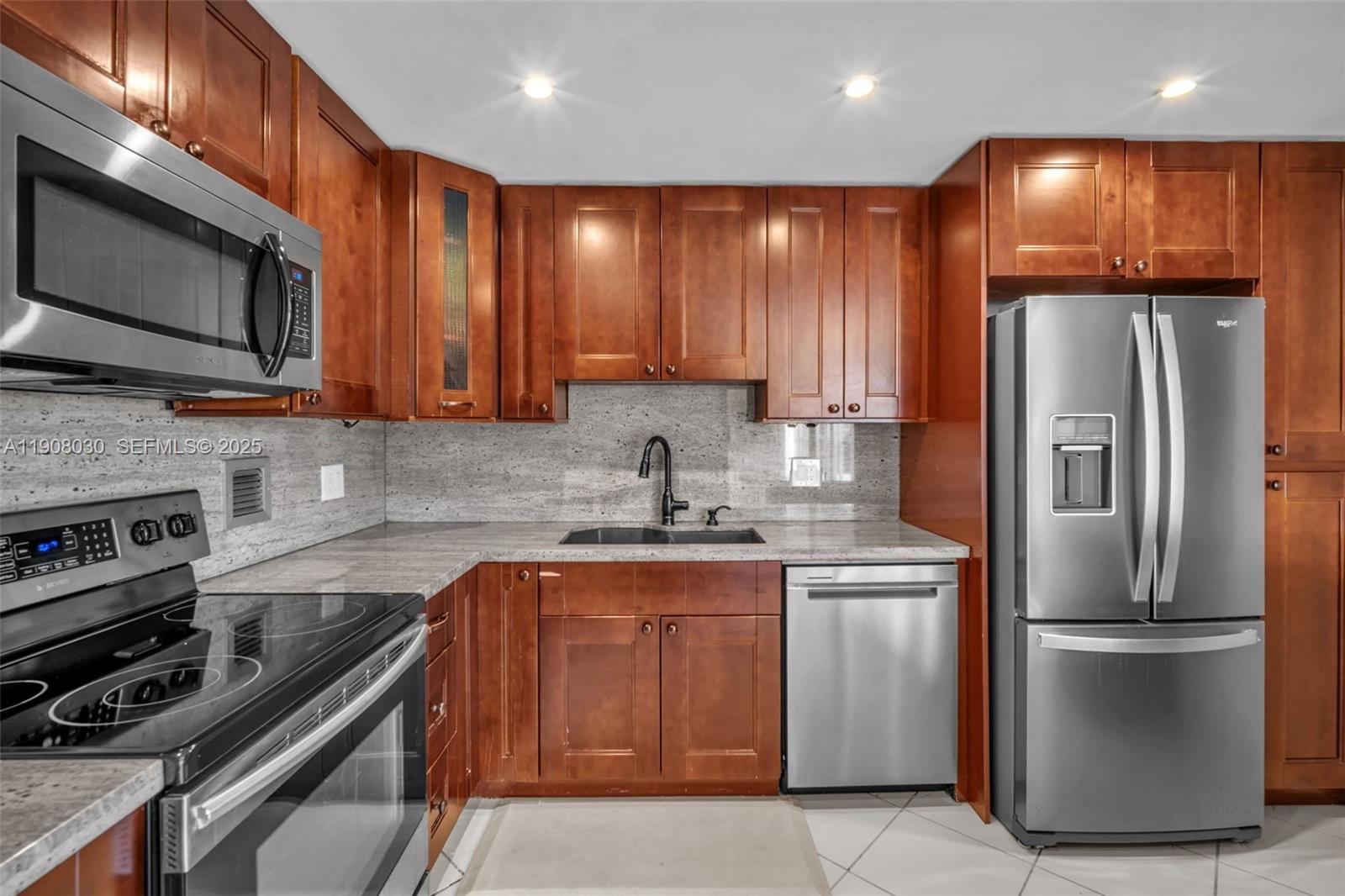 2810 North 46th Avenue, Unit F655 Hollywood, FL 33021 - Photo 24 of 52 a kitchen with stainless steel appliances granite countertop a refrigerator stove and microwave