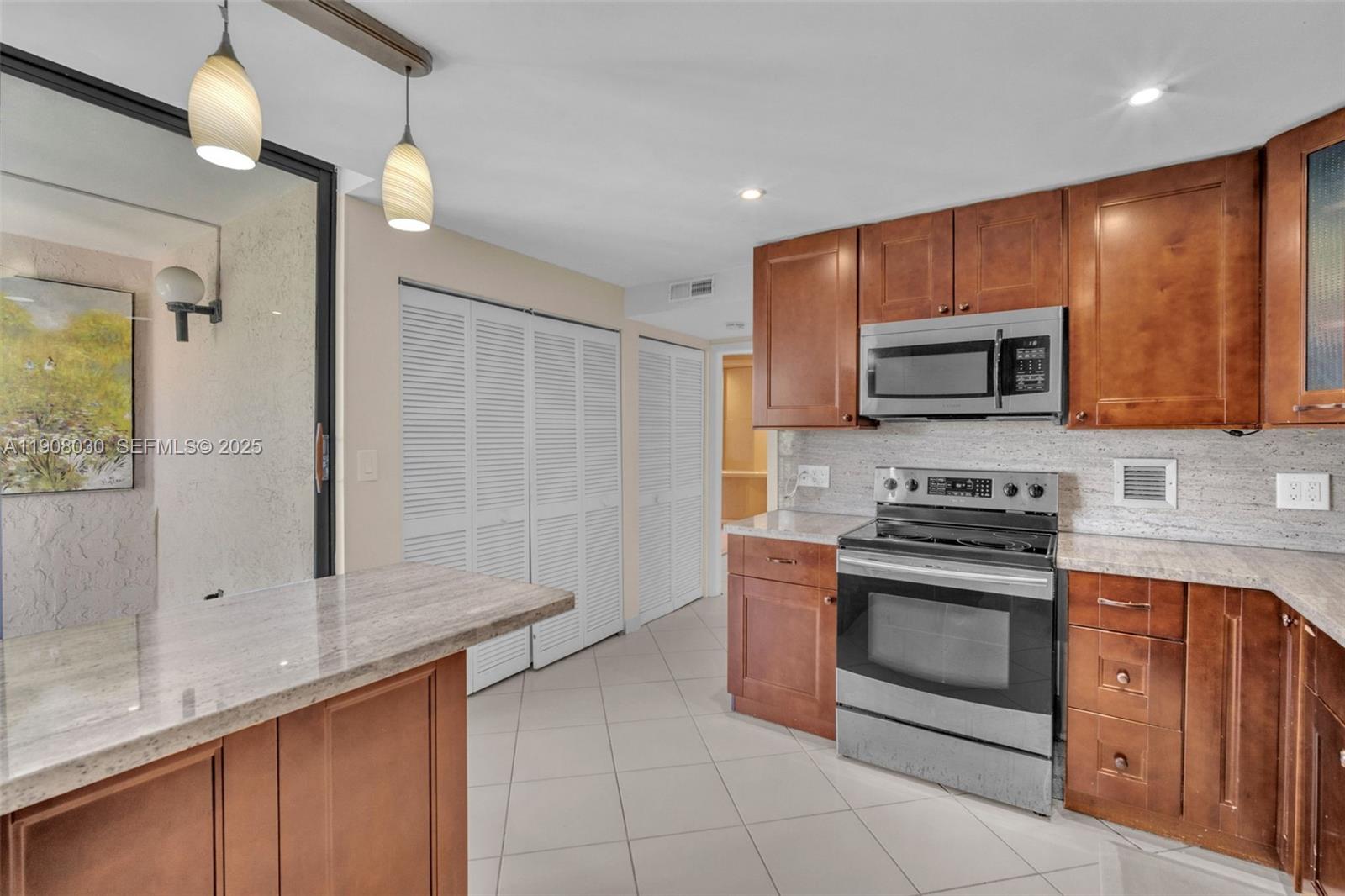 2810 North 46th Avenue, Unit F655 Hollywood, FL 33021 - Photo 27 of 52 a kitchen with stainless steel appliances granite countertop a stove a sink and a microwave