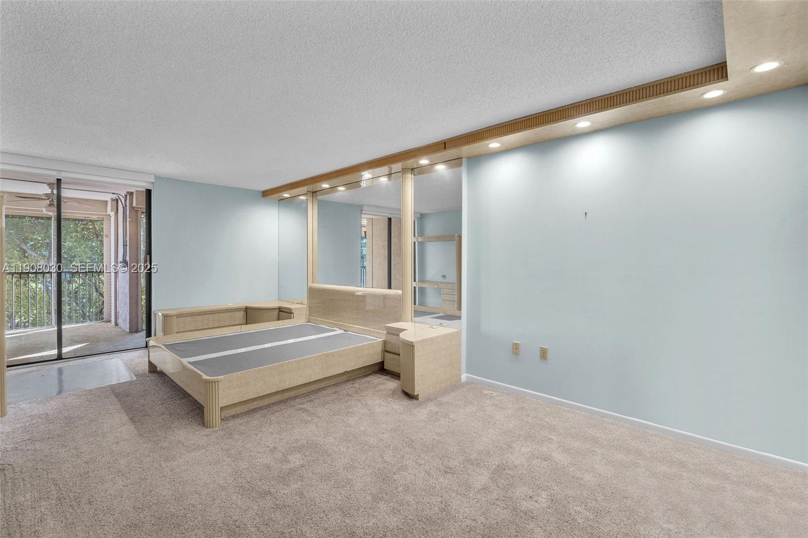 2810 North 46th Avenue, Unit F655 Hollywood, FL 33021 - Photo 37 of 52 a spacious bedroom with a bed and glass door