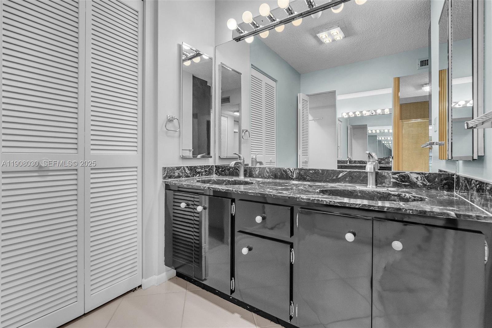 2810 North 46th Avenue, Unit F655 Hollywood, FL 33021 - Photo 39 of 52 a bathroom with a granite countertop sink a large mirror and vanity