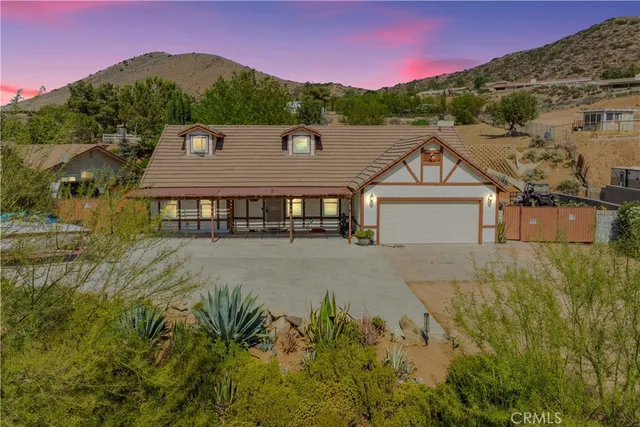 a aerial view of a house with a yard and a large tree