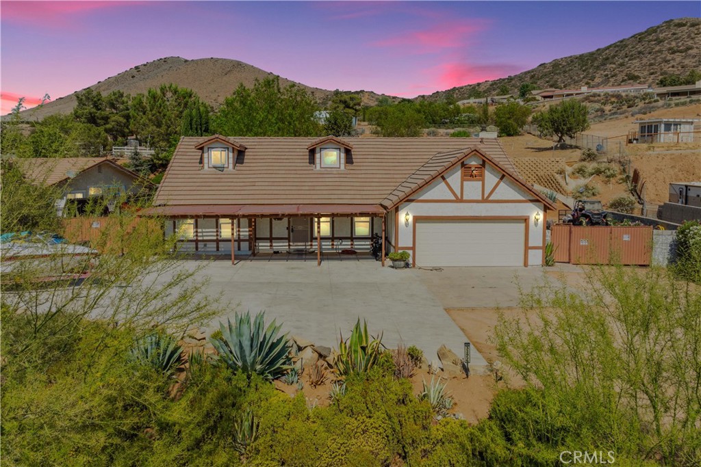 a aerial view of a house with a yard and a large tree