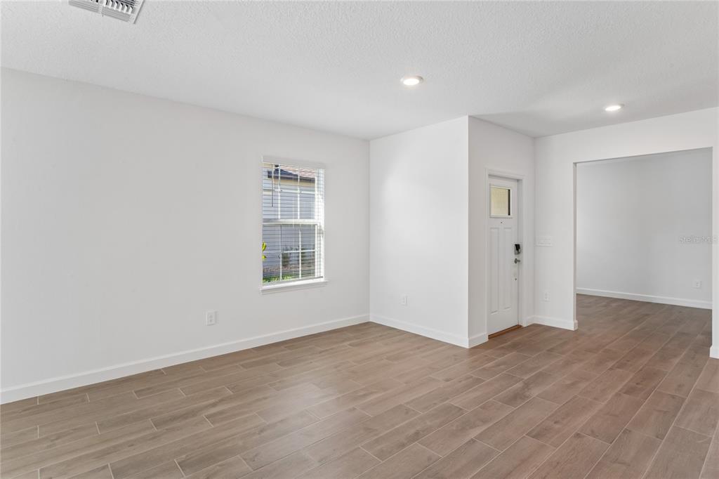 6692 Homebound Way New Port Richey, FL 34653 - Photo 18 of 47 a view of an empty room with wooden floor and a window