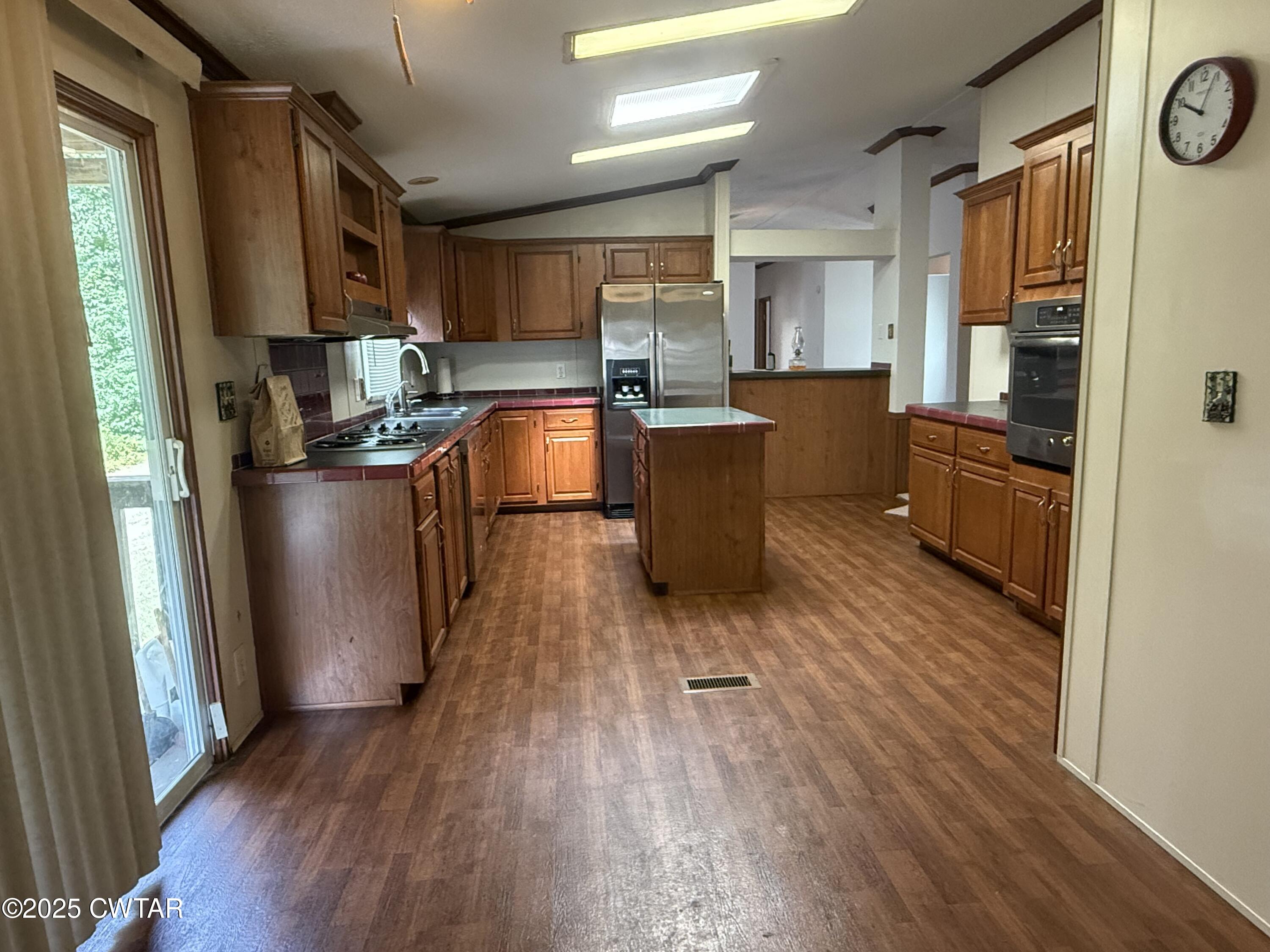 501 Post Office Road Michie, TN 38357 - Photo 10 of 20 a kitchen with stainless steel appliances a refrigerator a sink dishwasher a stove and white countertops with wooden floor