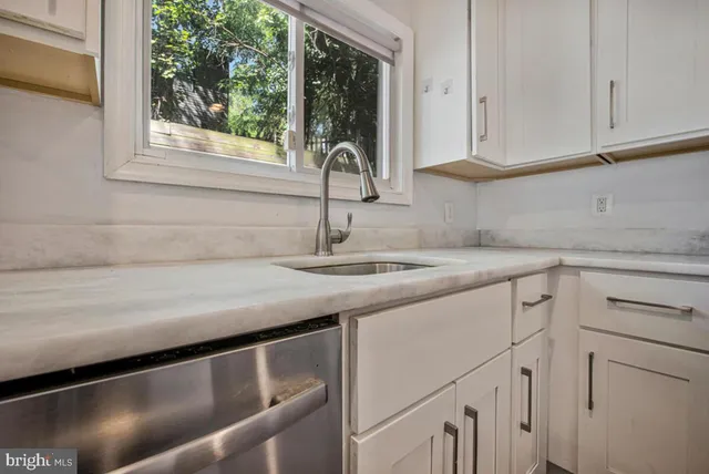 a kitchen with stainless steel appliances granite countertop a sink and dishwasher next to a window