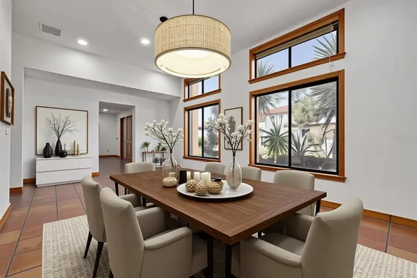 a view of an empty room with window and chandelier fan