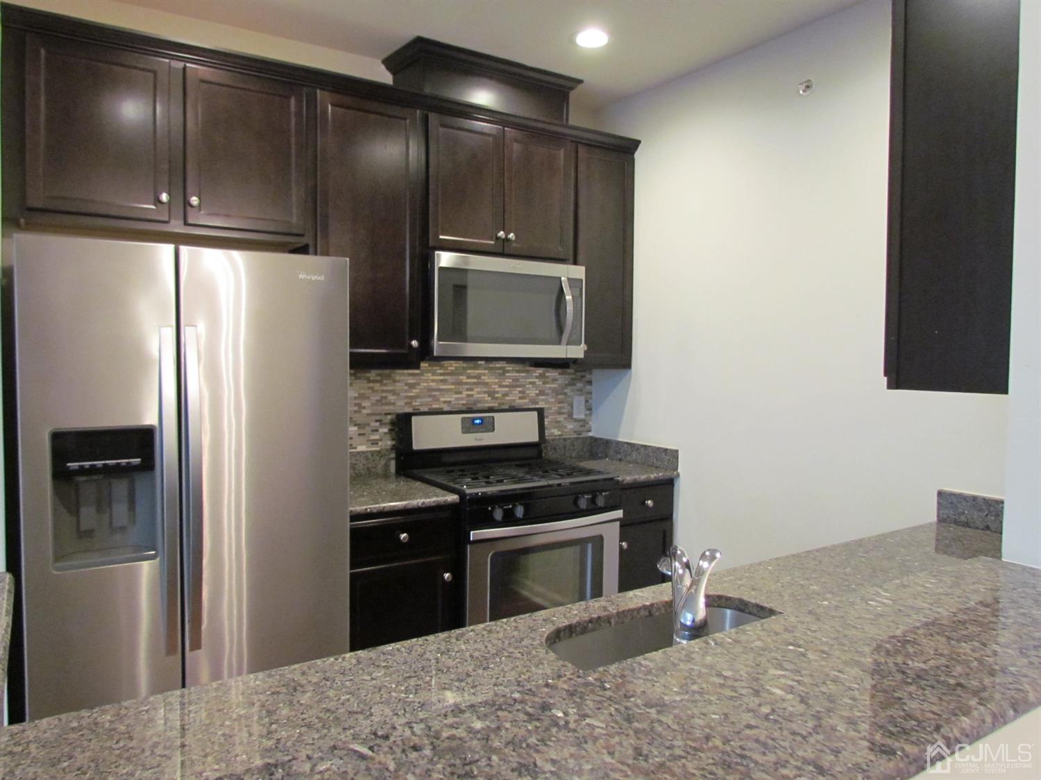 746 Strassle Way South Plainfield, NJ 07080 - Photo 9 of 25 a kitchen with granite countertop a refrigerator stove and microwave