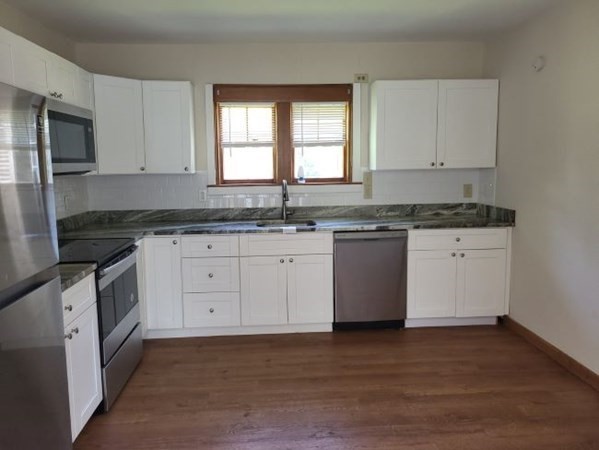 22 Pine Street Leicester, MA 01524 - Photo 4 of 13 a kitchen with granite countertop white cabinets stainless steel appliances a sink and a window