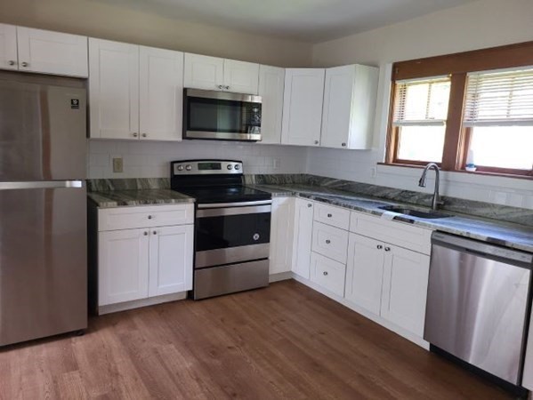 22 Pine Street Leicester, MA 01524 - Photo 5 of 13 a kitchen with granite countertop white cabinets sink and stainless steel appliances