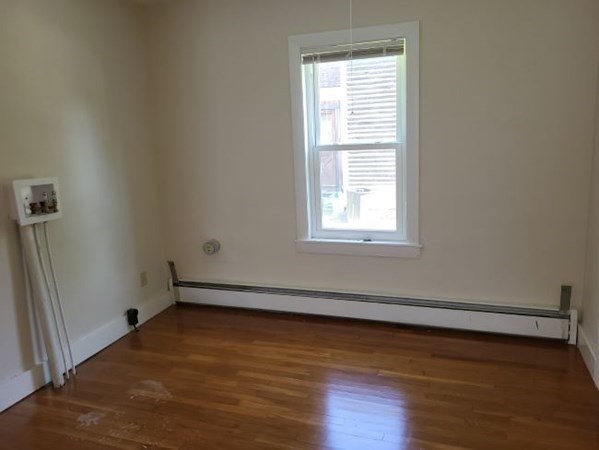 22 Pine Street Leicester, MA 01524 - Photo 9 of 13 an empty room with wooden floor and windows